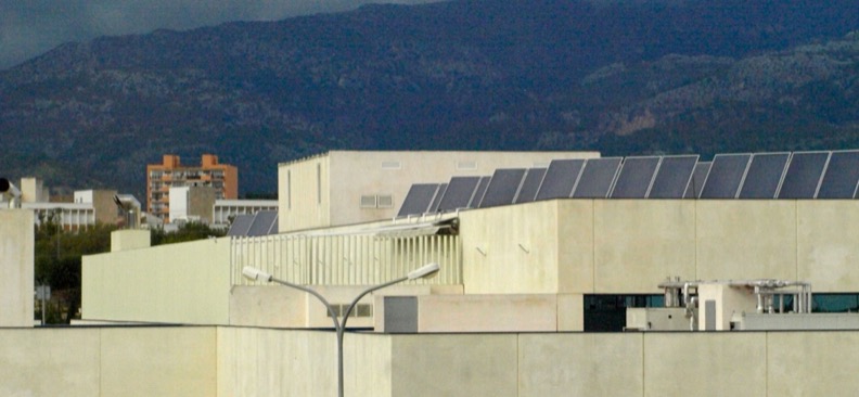 Fila de captadores solares térmicos planos, inclinados sobre la cubierta del hospital de Inca, en Mallorca